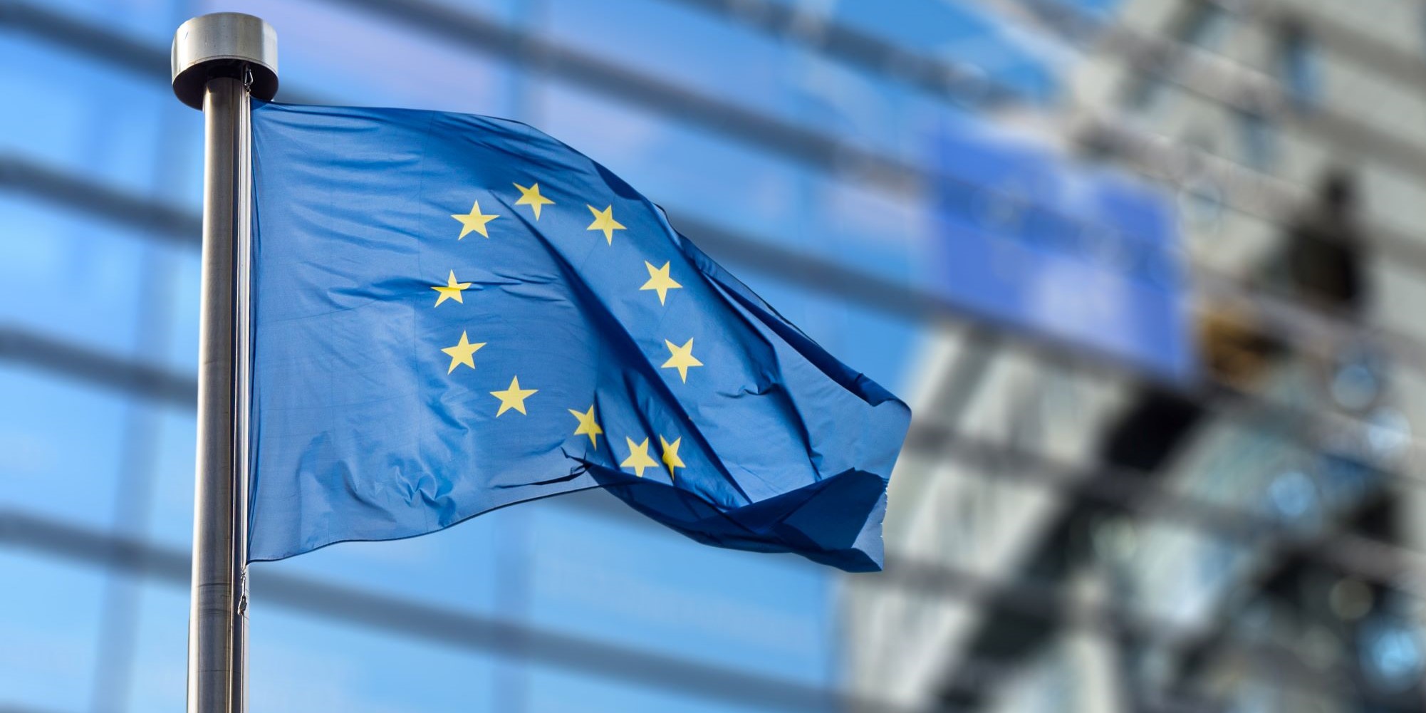 Flaga Unii Europejskiej na tle budynku.