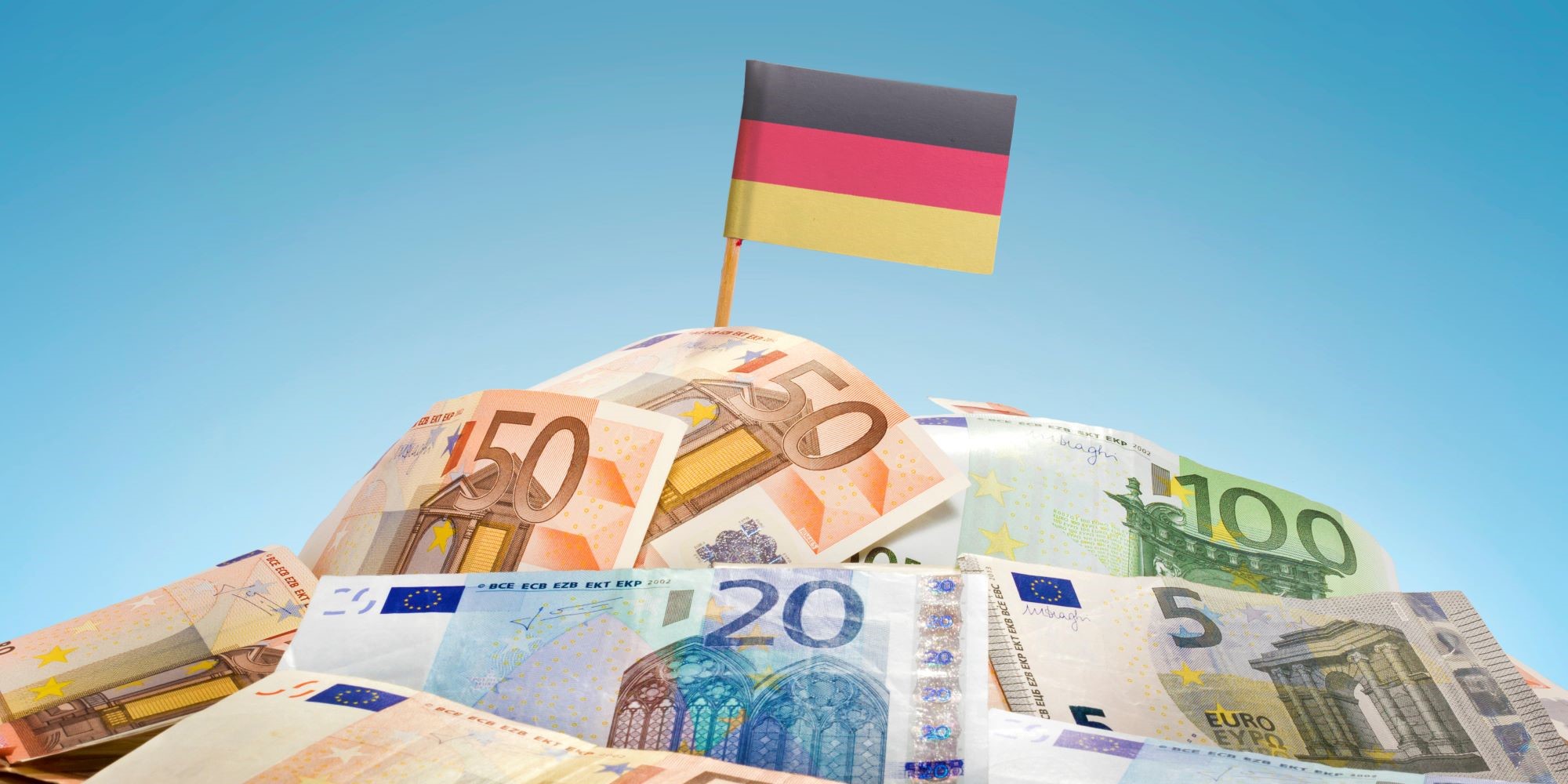 Stos z banknotów euro, na górze flaga Niemiec.