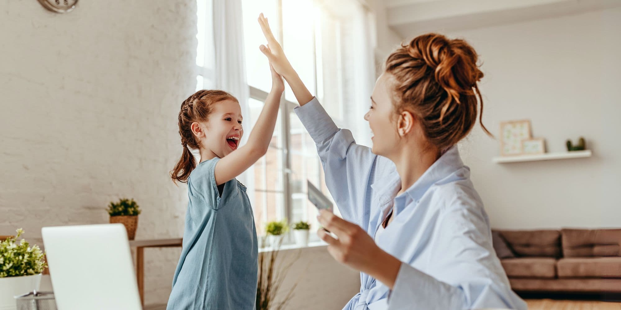 Mama przybija piątkę z córką po tym jak założyła konto bankowe dla dziecka