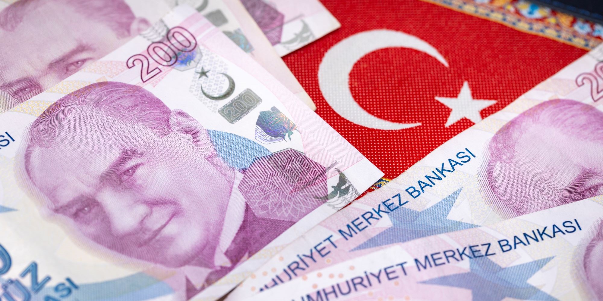 Banknoty liry tureckiej ułożone na tureckiej fladze.