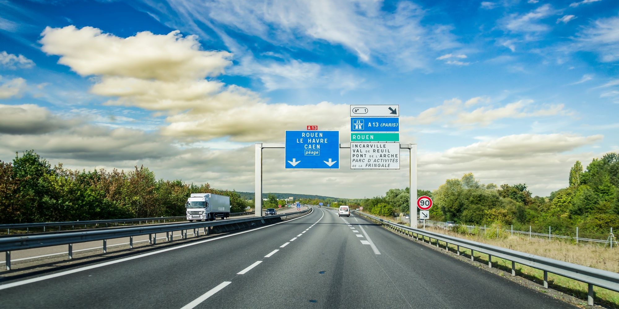 Autostrada we Francja, zachmurzone niebo w tle.