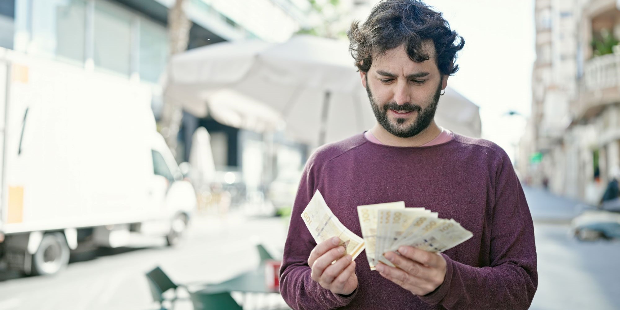 Mężczyzna trzymający plik banknotów (korona duńska)