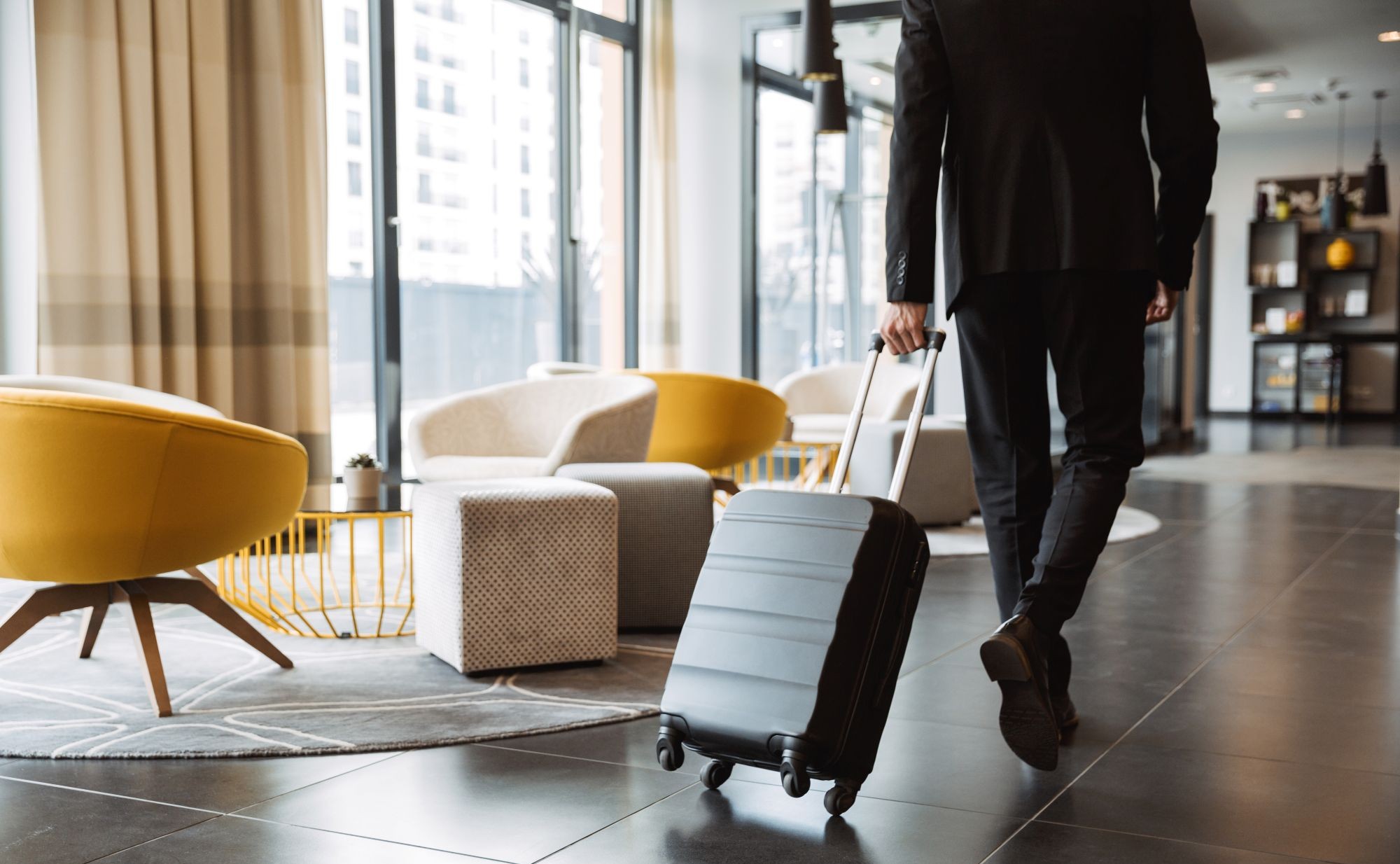 Mężczyzna ciągnie walizkę w hotelowym holu